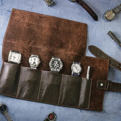 A collection of vintage watches in a handmade leather roll case, perfect for travel.