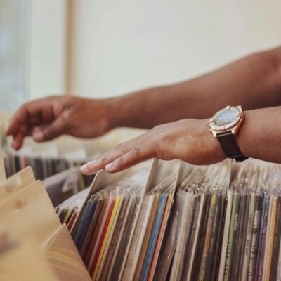 Close-up of hands browsing vinyl records in a store, showcasing a classic vintage collection.